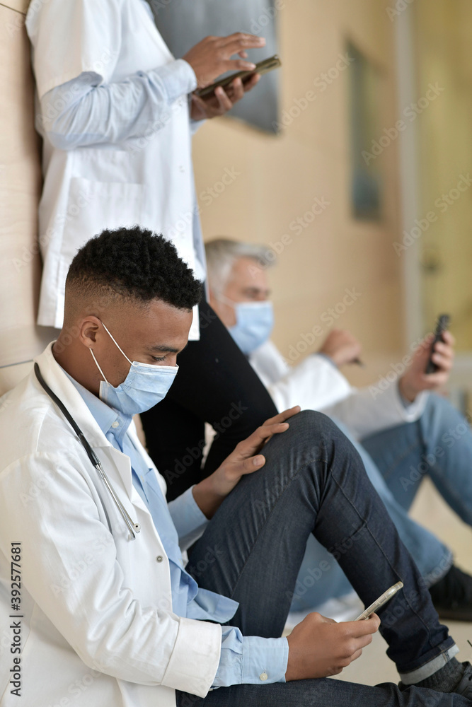Young doctor taking a break in hospital corridor Young doctor taking a break in hospital corridor