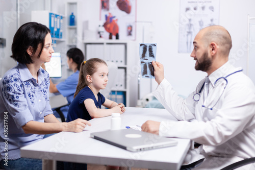 Pediatrician examining sick child radiography during medical consultation. Healthcare physician specialist in medicine providing health care services treatment examination.