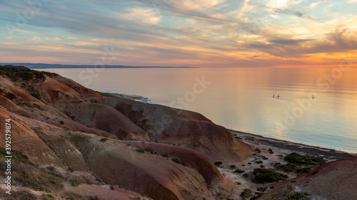 The beautiful Seaford beach at sunset with standup paddle boarders in the distance in South Australia on November 2 2020
