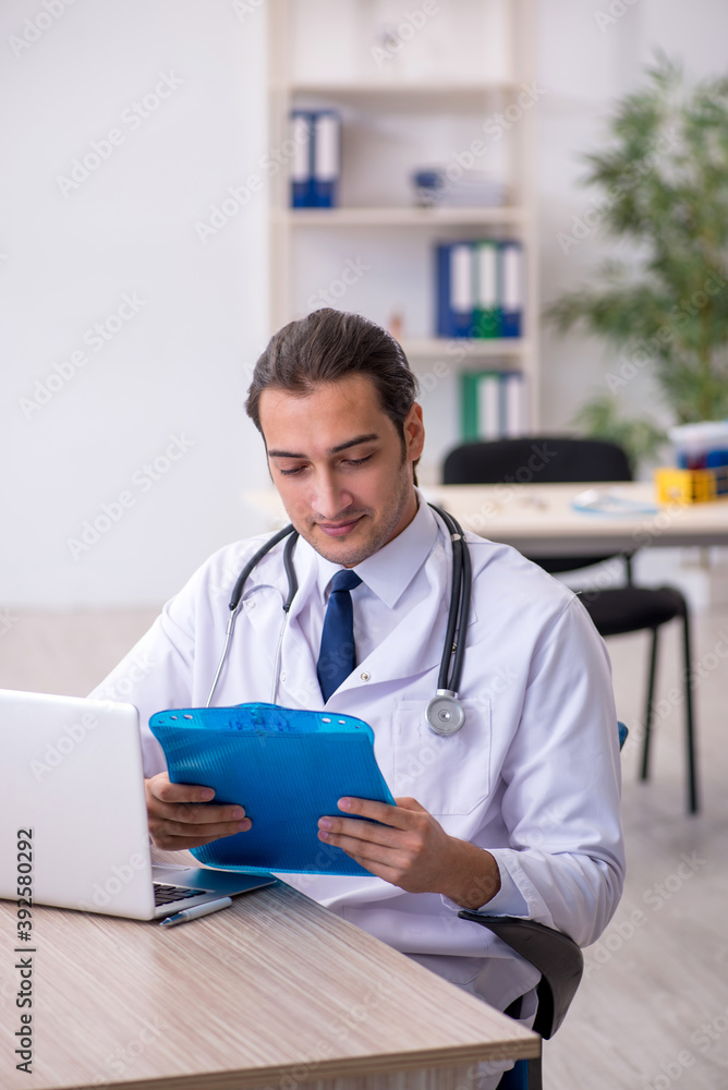 Young male doctor taking notes at the hospital Young male doctor taking notes at the hospital