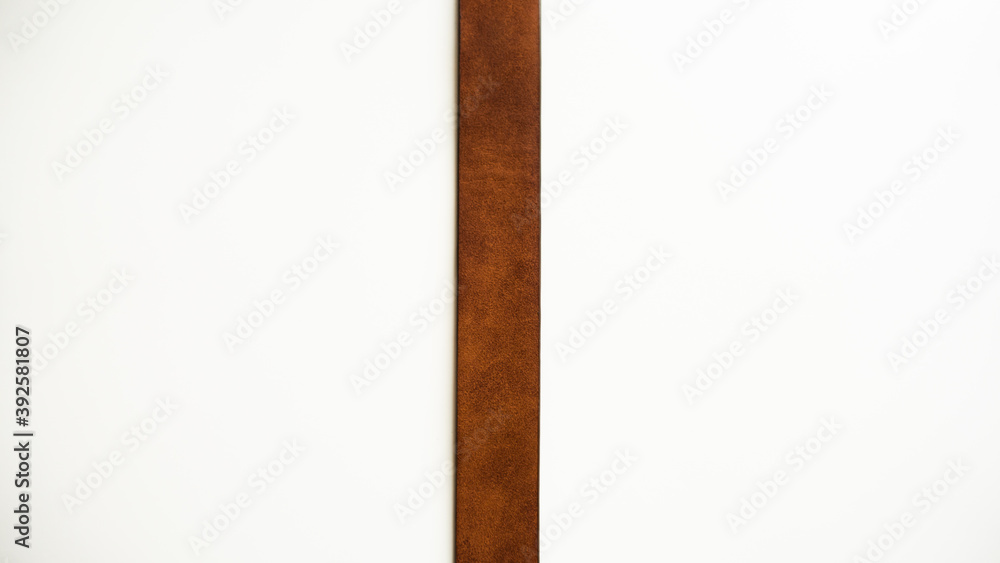 Obraz premium Dividing strip. Brown leather strap on a white background.