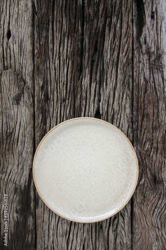 Empty white ceramics plate and on wooden background.