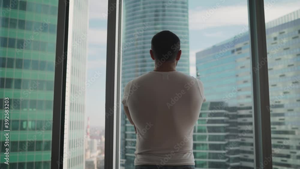 Man in a t-shirt on a background of panorama. Portrait of handsome t-shirt guy crossing arms on chest on city background of tall building. Headshohot of a happy businessman face in caual wear. Man in a t-shirt on a background of panorama. Portrait of handsome t-shirt guy crossing arms on chest on city background of tall building. Headshohot of a happy businessman face in caual wear.
