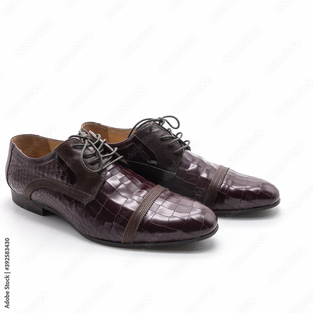 Men's elegant demi-season low shoes made of dark burgundy genuine leather. Snake embossing, lacing, thin sole. Isolated over white background.
