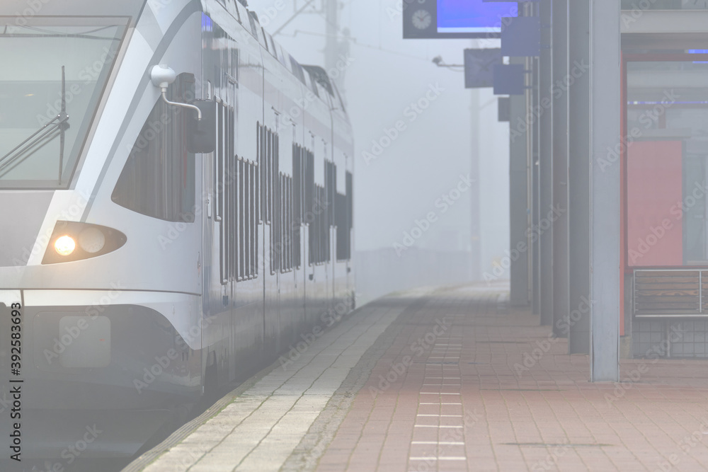 A foggy morning on the Railway Station. The commuter train on the station. Espoo, Finland.