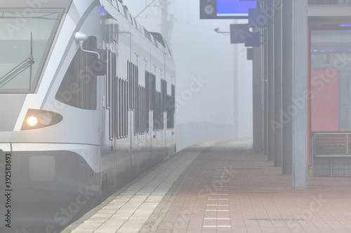 Obraz na płótnie A foggy morning on the Railway Station. The commuter train on the station. Espoo, Finland. w salonie