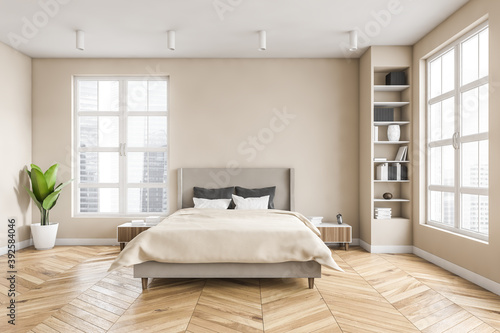 Wooden bedroom with bed and linens, beige walls and window with a city view