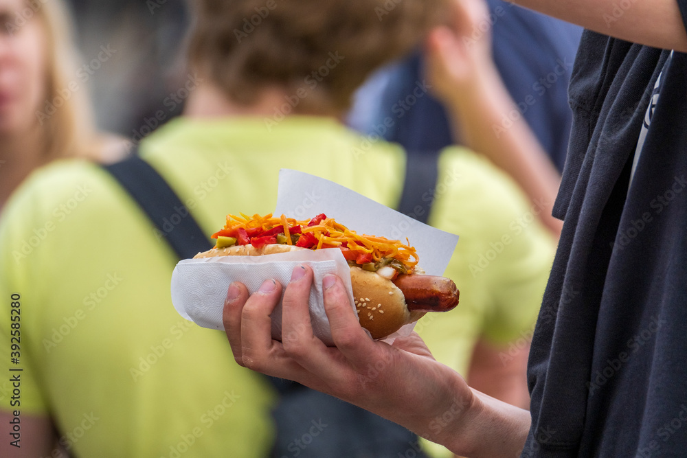 Crop man with hot dog in crowd
