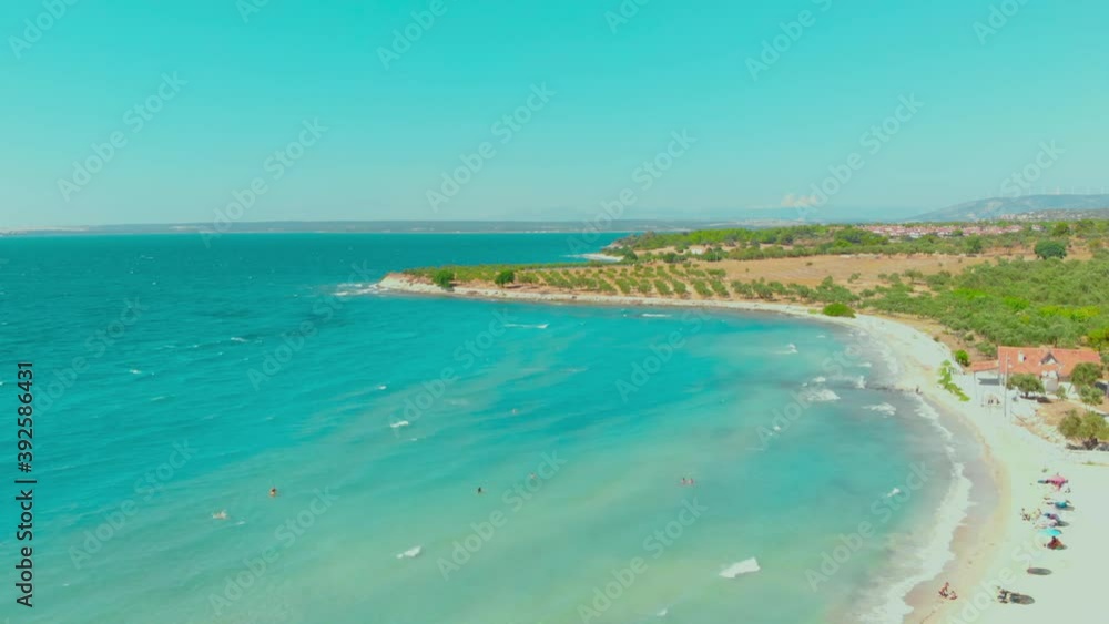 Aerial view of white beach and turquoise water landscape on a windy summer day in Didim, Turkey. Colorful umbrellas at the white beach in Aegean coast of Turkey Aerial view of white beach and turquoise water landscape on a windy summer day in Didim, Turkey. Colorful umbrellas at the white beach in Aegean coast of Turkey