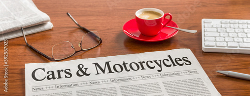A newspaper on a wooden desk - Cars and Motorcycles