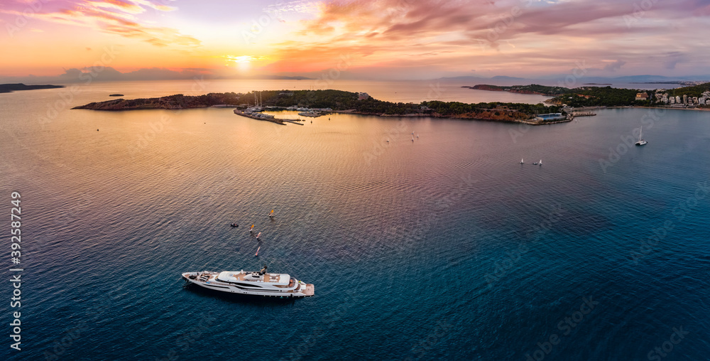 Panoramic aerial view to the bay of Vouliagmeni with the Laimos peninsula on the south coast of Athens, Greece, during a romantic sunset
