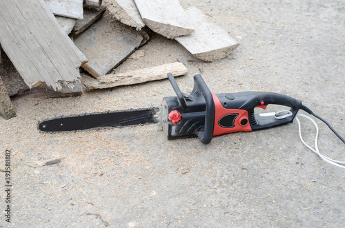 Wallpaper Mural Black hand power saw lies near the firewood Torontodigital.ca