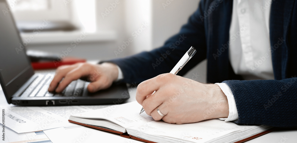 Cropped view of businessman works with financial papers at the table Cropped view of businessman works with financial papers at the table