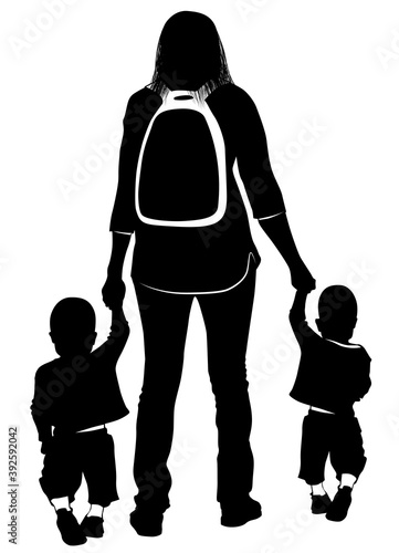 Silhouette of a young mother leading the hands of her children