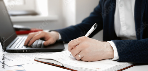 Cropped view of businessman works with financial papers at the table