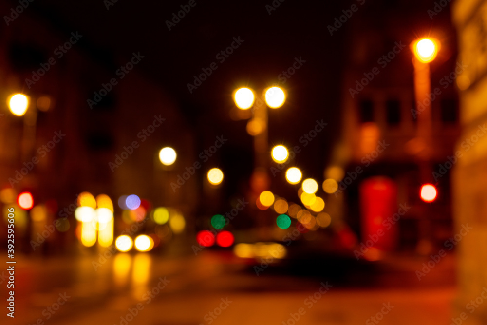 Cozy evening in the festive city. Blurred image of street with lights for Christmas and New Year celebration time or calm evening. Shining avenue at midnight. Abstract holiday  background.