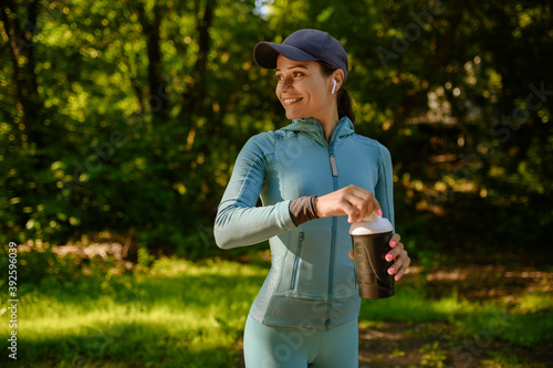 Training in park, smiling woman holds water