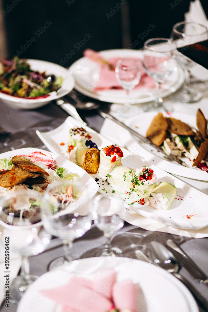 Festive table setting with snacks and flowers in the restaurant. Wedding table decor for guests Festive table setting with snacks and flowers in the restaurant. Wedding table decor for guests
