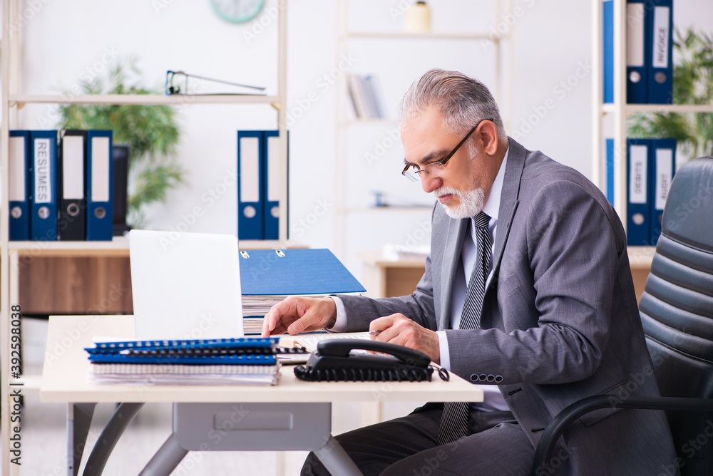 Old male employee working in the office Old male employee working in the office