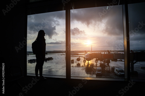 A silhuette of a woman with backpack in an airport