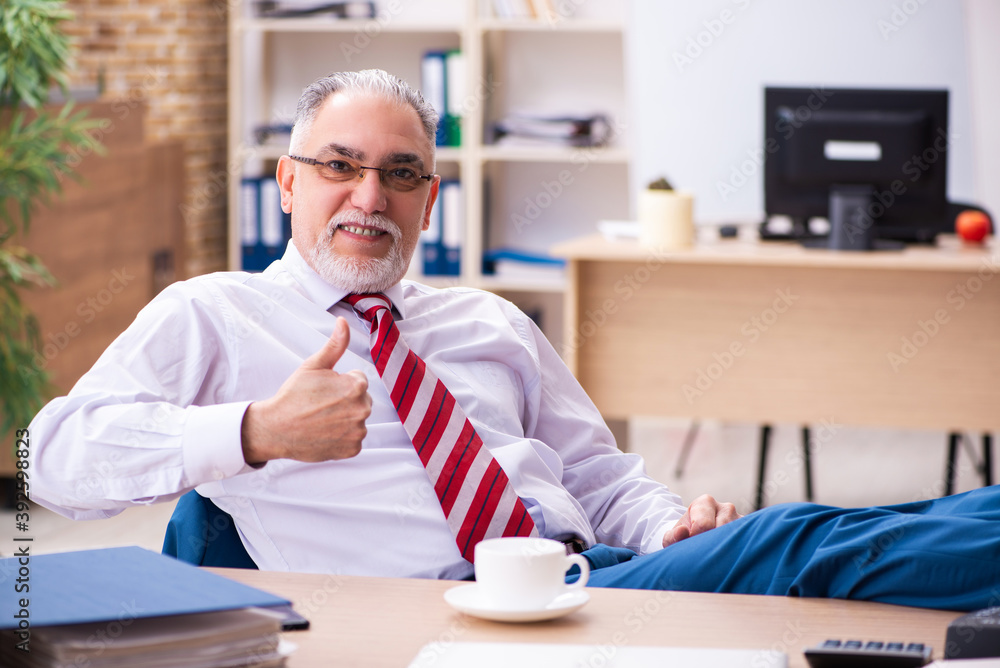 Old male employee enjoying coffee during coffee break Old male employee enjoying coffee during coffee break