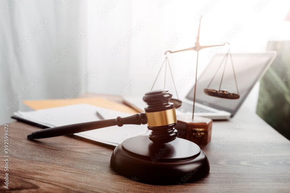 Business and lawyers discussing contract papers with brass scale on desk in office. Law, legal services, advice, justice and law concept picture with film grain effect Business and lawyers discussing contract papers with brass scale on desk in office. Law, legal services, advice, justice and law concept picture with film grain effect