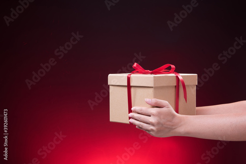 Fototapeta Naklejka Na Ścianę i Meble -  hand holding gift box with Merry Christmas and Happy New Year
