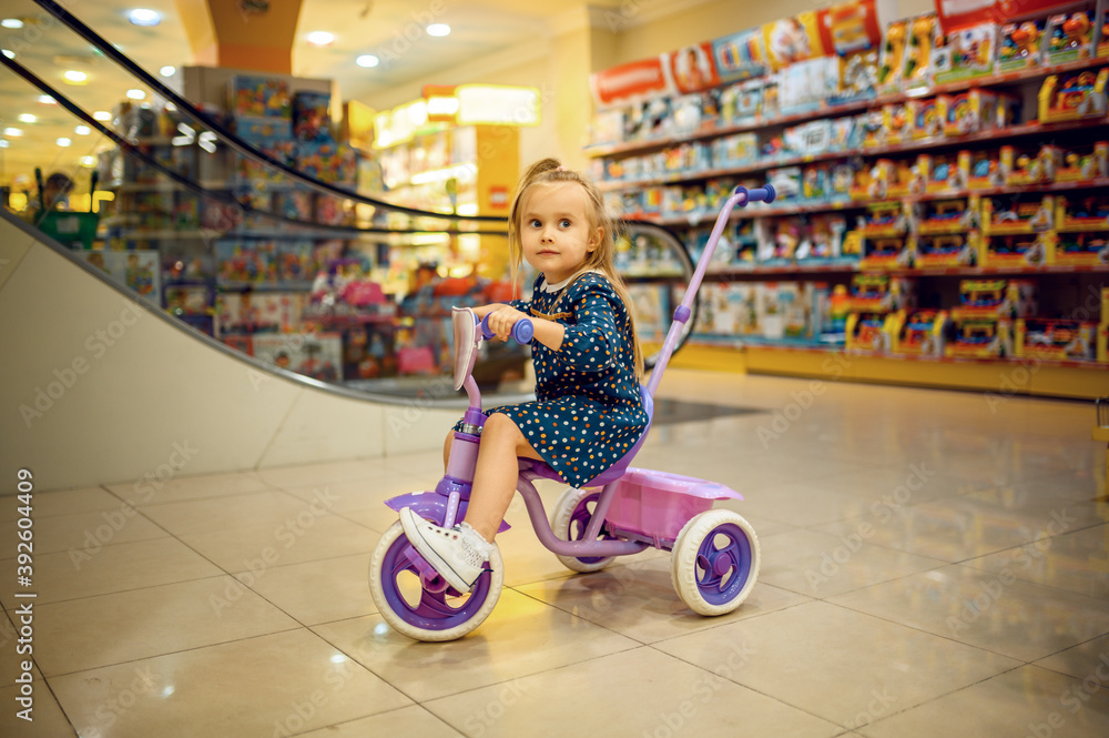 Little baby riding on bicycle in children's shop Little baby riding on bicycle in children's shop