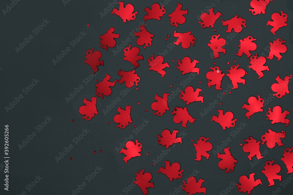 Red confetti of Santa Claus on a dark background. Free space for recording. Selective focus