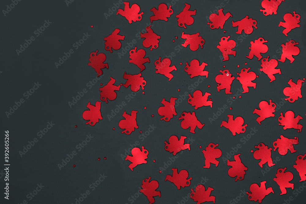 Red confetti of Santa Claus on a dark background. Free space for recording. Selective focus Red confetti of Santa Claus on a dark background. Free space for recording. Selective focus