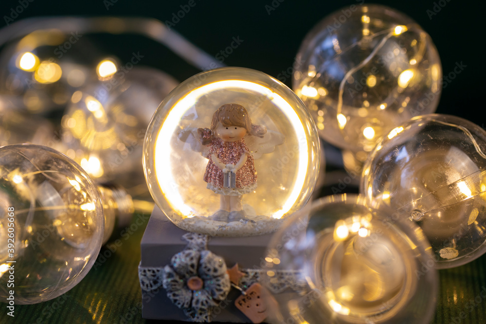 decorative snow globe with a girl angel on a dark wooden background decorative snow globe with a girl angel on a dark wooden background
