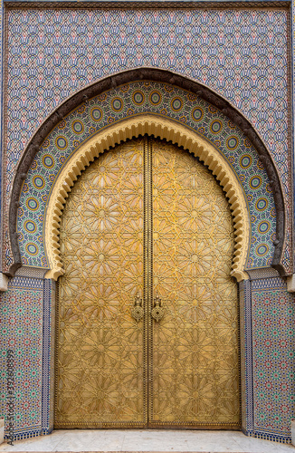 Beautiful details of Bab Majzen door of ornate golden metal on the entrance gates to the Royal Palace in Fes, Morocco ( Fez ). Ornamented geometric pattern and handles or knockers of Dar al-Makhzen