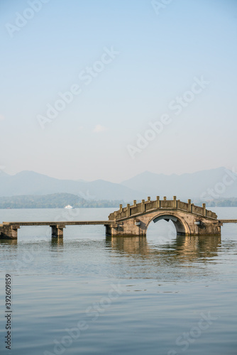 The mountain and lake landscape at West Lake in Hangzhou, China, on a sunny day.