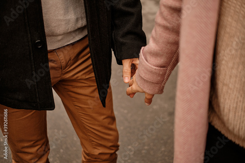 Close up of loving couple holding hands while walking