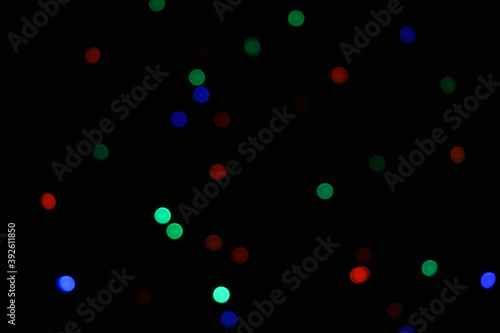 green and blue and orange abstract urban realistic blurred glitter light colorful texture on black.