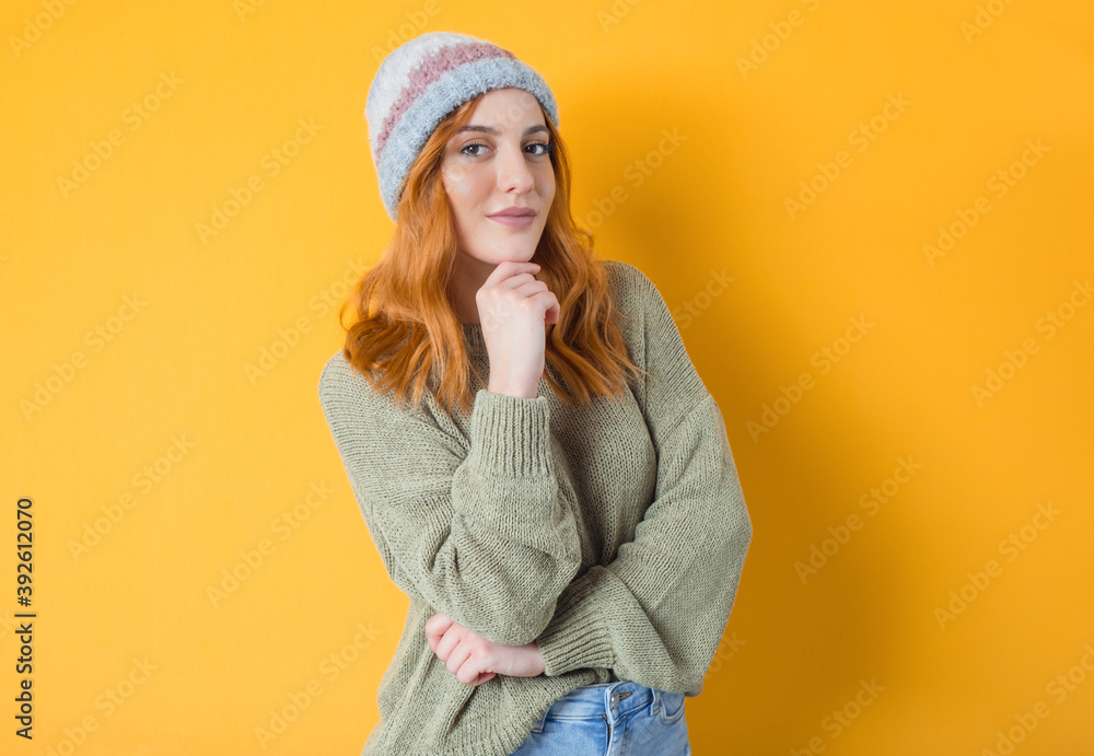 Young beautiful woman posing while looking to camera, isolated on yellow background. Pretty playful girl Young beautiful woman posing while looking to camera, isolated on yellow background. Pretty playful girl