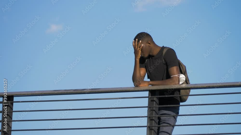 worries, thoughts - black man leaning against the balustrade of the bridge worries, thoughts - black man leaning against the balustrade of the bridge