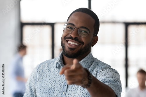 We are looking for you. Active cheerful young black male hr looking at camera pointing finger to spectator wanting get him to company, portrait of friendly african man leader selecting new team member