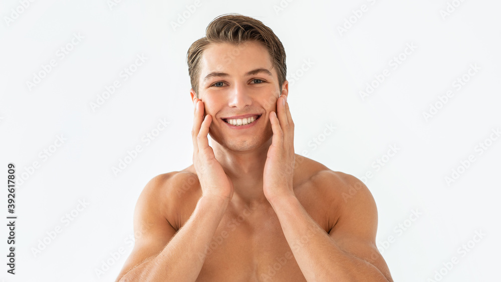 Obraz premium Portrait of man touching his face at white studio