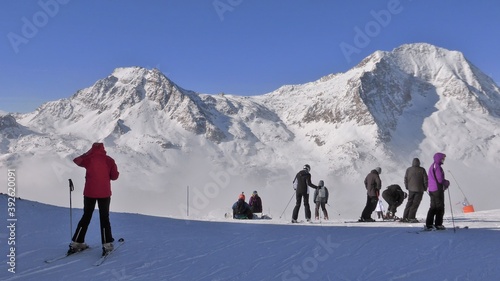 Skieurs au sommet d'une montagne couverte de neige dans les Alpes, prêts à s'élancer sur une piste de ski, à Aussois dans la Haute-Maurienne en Savoie (France)