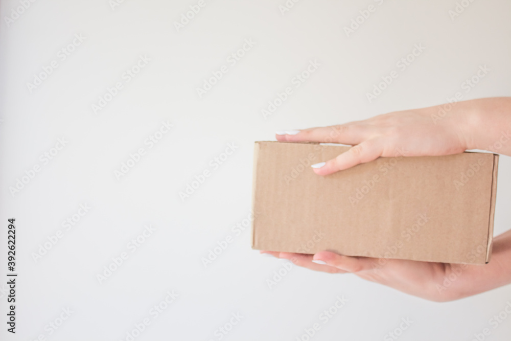 Сourier delivered the package and hands it over to the recipient. Cardboard box with parcel in the hands of a satisfied recipient. Concept of delivery time of goods, fast delivery Сourier delivered the package and hands it over to the recipient. Cardboard box with parcel in the hands of a satisfied recipient. Concept of delivery time of goods, fast delivery
