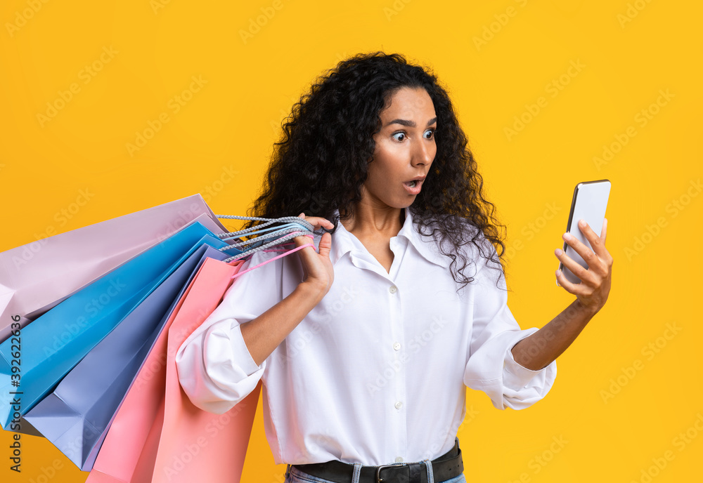 Shocked shopaholic woman checking online banking money balance in app on smartphone Shocked shopaholic woman checking online banking money balance in app on smartphone