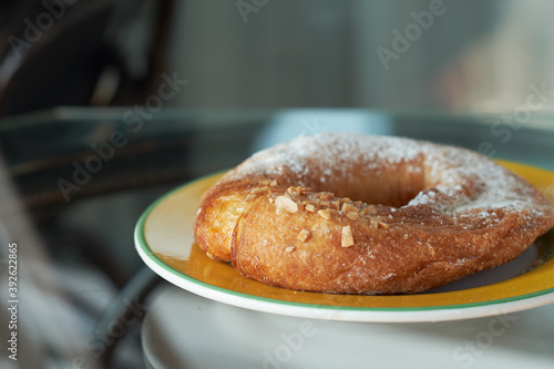 Delicious sugar and almond donut on a plate.