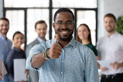 Best ever. Portrait of loyal excited black male client customer demonstrating thumb up sign recommending good product service, happy african employee looking at camera glad to work in company staff