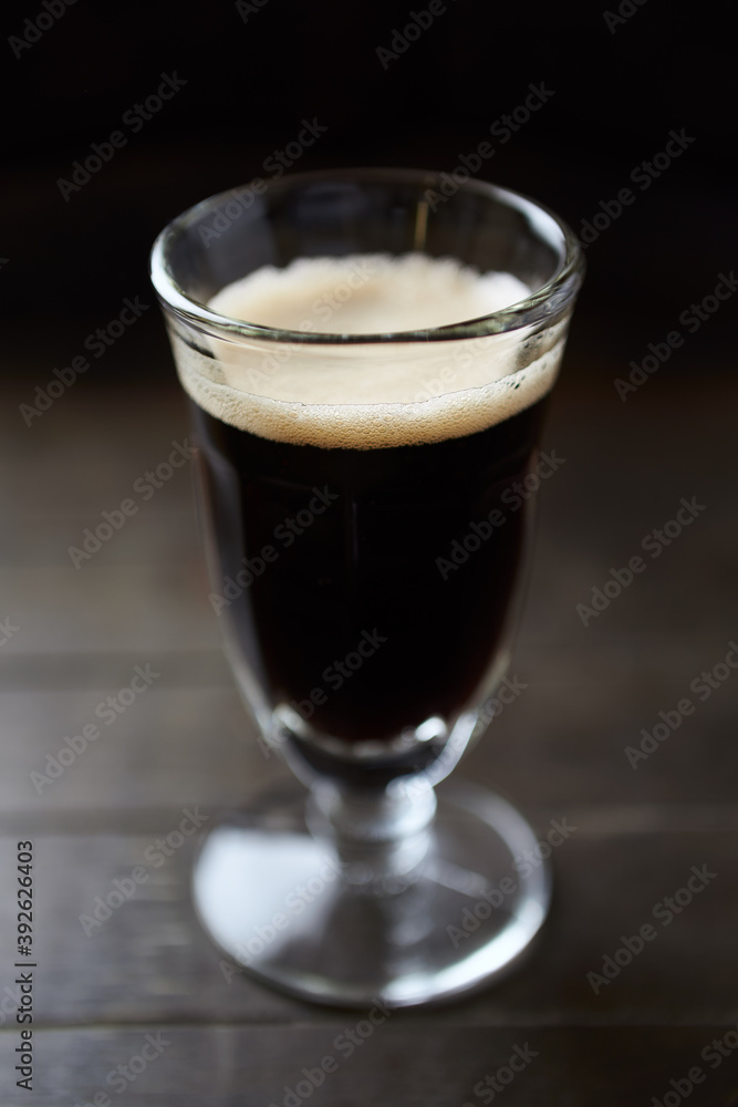 Glass of dark beer on dark wooden background. close up. Glass of dark beer on dark wooden background. close up.