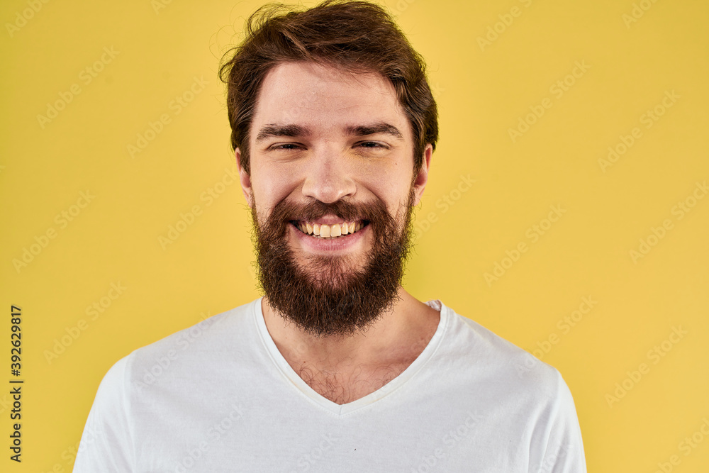 A man in a white t-shirt gestures with his hands lifestyle cropped view yellow background more fun A man in a white t-shirt gestures with his hands lifestyle cropped view yellow background more fun
