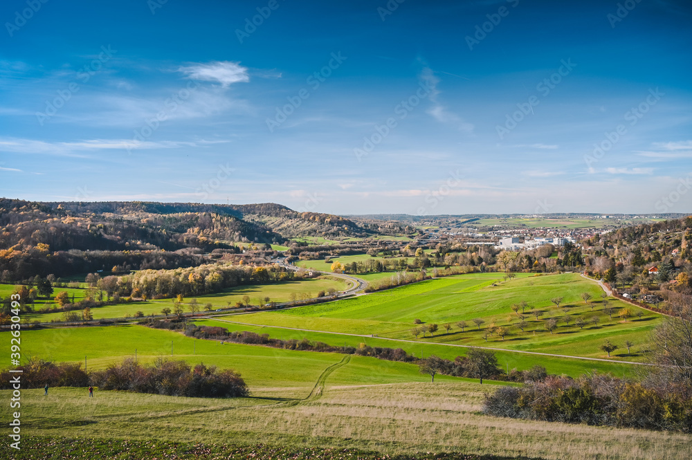 Panoramic view from the Schumisberg, a hill near the city of Leonberg, Germany. Fresh fields, a curvy country road and forested hills are in the background.
