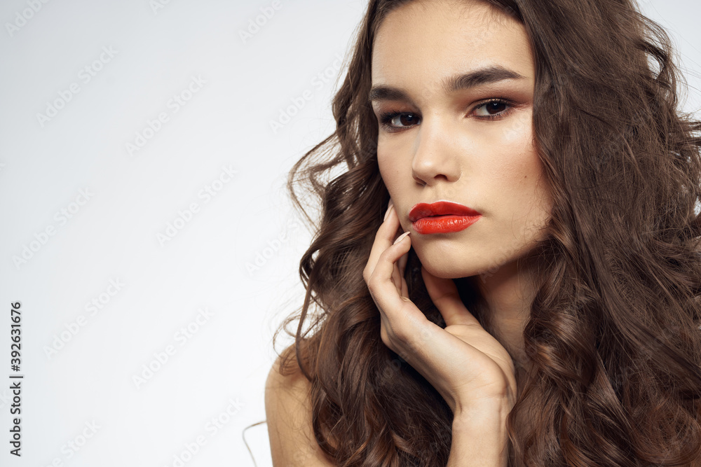 woman with bare shoulders wavy hairstyle glamor makeup light background