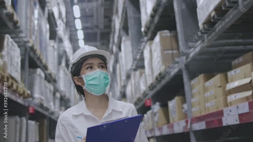 Warehouse worker or Asian woman Happy labor wear medical mask to prevent Coronavirus and PM2.5 dust. Wear hardhat for protection while working in the transportation industry. Concept key worker Warehouse worker or Asian woman Happy labor wear medical mask to prevent Coronavirus and PM2.5 dust. Wear hardhat for protection while working in the transportation industry. Concept key worker