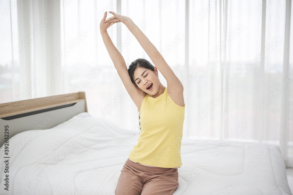 Young woman wake up in the morning and stretching on her bed Young woman wake up in the morning and stretching on her bed